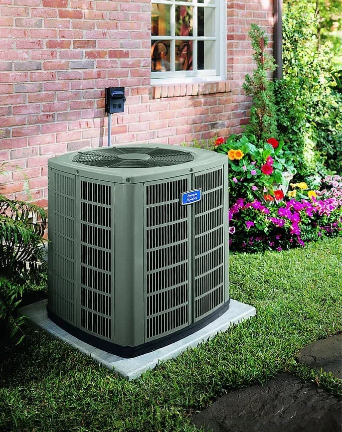 Outdoor AC unit next to a brick house